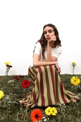 Falda larga de gasa con diseño de rayas verticales en tonos verde oliva y bordó. Presenta una silueta amplia y fluida con cierre lateral oculto.