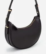 Bolso baguette de formato media luna, confeccionado en poliuretano con acabado liso. Cuenta con correa de hombro ajustable con herrajes metálicos dorados y cierre superior mediante cremallera.