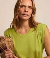 Vestido midi color verde, sin mangas, con cuello redondo y hombreras marcadas. Incluye un cinturón de cordón rústico para ajustar en la cintura.