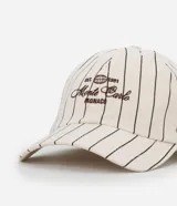 Gorra de sarga color crudo con rayas verticales negras y bordado frontal con el texto "EST. 1991 Monte Carlo Monaco".