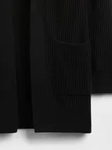 Saco abierto de punto acanalado, con mangas largas y bolsillos frontales. Diseño versátil y ligero sin botones.