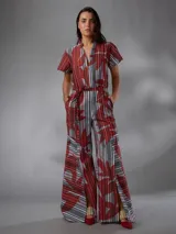 Mono de lino mezcla con estampado vegetal en tonos rojos, grises y blancos, de manga corta, escote en V y piernas amplias con cinto incorporado para ajustar la cintura.
