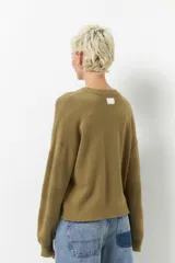 Sweater color borgoña de manga larga, tejido tramado y cuello redondo con puños elastizados.