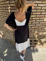 Túnica negra con bloque inferior en blanco y detalle de espalda descubierta con pieza de tela blanca.