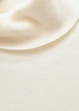 Buzo de punto fino en cashmere, color crema, con cuello vuelto y manga corta.