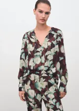 Pantalón largo estilo flare de tiro medio, con cintura elástica y forro interior, con estampado floral en tonos oscuros y verdosos.