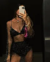 Vestido corto de red con brillos, mangas largas y cuello redondo. Incluye top y short negro.