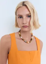 Top de algodón color naranja, sin mangas, con tirantes anchos, escote recto y cierre frontal con botones.
