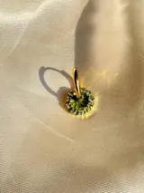 Arito dorado con forma circular, centro negro y strass blancos alrededor. Se vende por unidad.