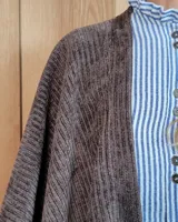 Ruana abierta de tejido de punto acanalado en color beige, con diseño holgado y caída fluida.