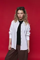 Camisa de manga larga color blanco, con cuello clásico y cierre frontal de botones de nácar. Presenta un corte cómodo y versátil.