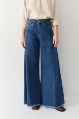 Pantalón de jean azul de tiro alto y corte wide leg súper amplio, con diseño de perneras ancha y terminación desmechada en el ruedo.