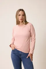 Remera de manga larga color rosado, con cuello redondo y puños con detalle de volados fruncidos.
