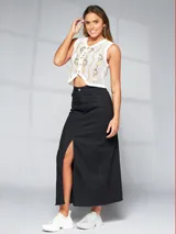 Falda larga negra de denim con abertura frontal y terminación desflecada.