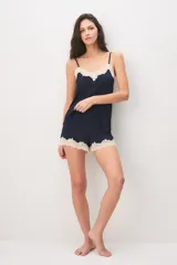 Pijama azul marino de poliamida y elastano, compuesto por una musculosa de tirantes finos con detalles de encaje beige en el escote y un short a juego con terminaciones de encaje en el ruedo.