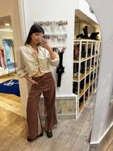 Pantalon sastrero de lino color marrón con paneles laterales en contraste beige, diseño de tiro alto y corte recto. Presenta un bordado de caballo en el bolsillo frontal.