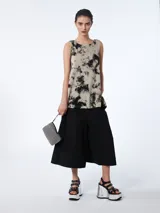 Musculosa de lino color beige con estampado abstracto en negro, de cuello redondo y corte acampanado.