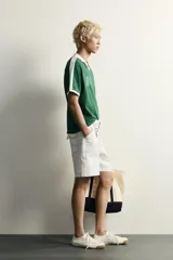 Polo de fútbol retro color verde oscuro, de corte regular fit, con cuello solapa blanco, mangas cortas con ribetes blancos y bandas en los hombros. Cuenta con estampado frontal del número 80 y un gráfico con efecto lavado.