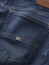 Pantalón de jean azul oscuro, corte slim, con cierre de botón y cremallera, cinco bolsillos y logo de Tommy Jeans en el bolsillo delantero y trasero.