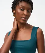 Blusa básica sin mangas marca Cortelle, confeccionada en poliamida con elastano. Presenta un diseño ajustado al cuerpo con escote cuadrado tanto en el frente como en la espalda y breteles medianos.