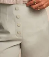 Short de sastrería negro, tiro alto, con cierre frontal de botones visibles.