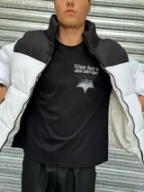 Campera puffer blanca con canesú y cuello alto negros, cierre frontal con cremallera y bolsillos laterales con cierre.