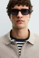 Polo de manga corta color blanco roto, con cuello solapa y cierre frontal de cremallera. Presenta un tejido de piqué estructurado y corte regular fit.