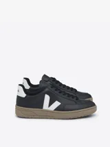 Championes Veja modelo V-12, confeccionados en cuero negro con el logo lateral en blanco y suela de goma en tono tostado.