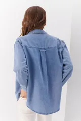 Camisa de jean celeste de manga larga con botones frontales y en los puños.