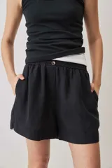 Short negro de tiro medio, confeccionado en lino, con diseño holgado y cierre clásico.