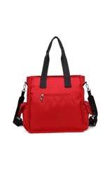 Cartera tipo bolso de Las Oreiro en color verde, con estampado de letras y corazones en tono sobre tono. Cuenta con doble asa superior de cinta negra, correa ajustable extraíble, bolsillos laterales y un aplique metálico con logo en el frente.