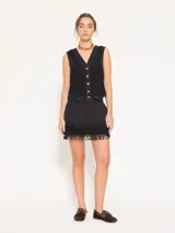 Minifalda negra con flecos en el ruedo, bolsillos laterales y traseros.