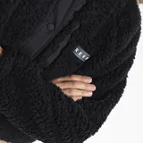Campera de polar tipo corderito en color violeta, con cuello alto, cierre frontal con botones a presión y detalles en negro. Cuenta con un bolsillo frontal con cierre y logo de la marca.