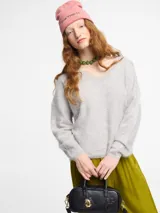 Sweater negro de silueta relajada con escote en V abierto, mangas largas y puños y ruedo cortos. Tejido extra suave tipo pelo.