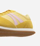 Championes amarillos con detalles en lila, de estilo vintage con punta redonda, cordones y recortes contrastantes. Suela marrón con base blanca.