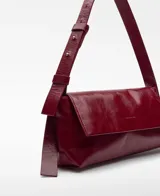 Bolso de hombro Adolfo Domínguez modelo Orión, confeccionado en piel de búfalo con acabado craquelado brillante. Presenta un diseño rectangular con solapa, cierre magnético y asa corta regulable con hebilla.