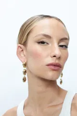 Aros colgantes dorados con tres dijes con textura irregular.