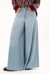 Jean de tiro alto con corte extra ancho y diseño de pierna fluida. Presenta bolsillos delanteros y traseros, cierre frontal con cremallera y botón metálico.