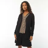 Chaqueta larga de punto fino color negro, con cuello en V y cierre frontal abotonado.