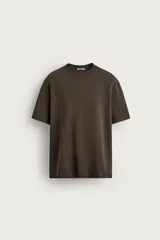 Remera blanca de corte relajado, con cuello redondo y mangas cortas.