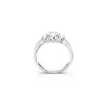 Anillo de compromiso o de cóctel con tres piedras centrales redondas engastadas en un engaste de tres puntas, flanqueadas por pavé de cristales más pequeños a lo largo de la banda.