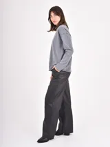 Pantalon de cuero sintetico color negro, de corte recto y holgado, con cintura elastizada y cordon de ajuste frontal.