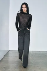 Jeans de tiro alto con corte wide leg y largo completo. Presenta diseño de cinco bolsillos, trabillas en la cintura y cierre frontal con cremallera y botón, con un acabado de efecto lavado.