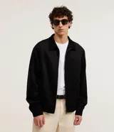 Campera Marfinno de color negro, confeccionada en poliéster con elastano, con cuello inglés, cierre frontal por cremallera, bolsillos laterales y elástico en el bajo.