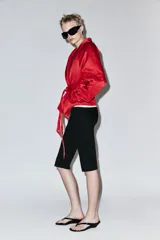 Cazadora corta de Zara color rojo, con cuello smoking, manga larga y cinturón ajustable del mismo tejido.