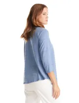 Blusa de modal texturizado en color azul, con cuello a la base y escote en V. Presenta un panel frontal decorado con apliques circulares nacarados y mangas tres cuartos.
