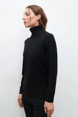 Polera negra de cuello alto y manga larga.