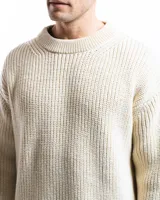 Sweater unisex color crema de lana merino, con cuello redondo y corte holgado.