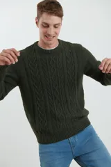 Sweater de tejido de punto color beige claro, con diseño de trenzas (aranes) en el frente y mangas de punto liso. Tiene cuello redondo.