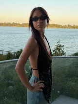 Top halter de encaje blanco con escote profundo y diseño de puntas asimétricas en el frente. Presenta un estilo delicado con transparencias y cierre frontal sutil.